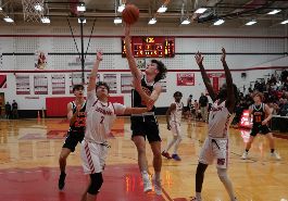  Mason Brodi shoots basketball into hoop under the basket